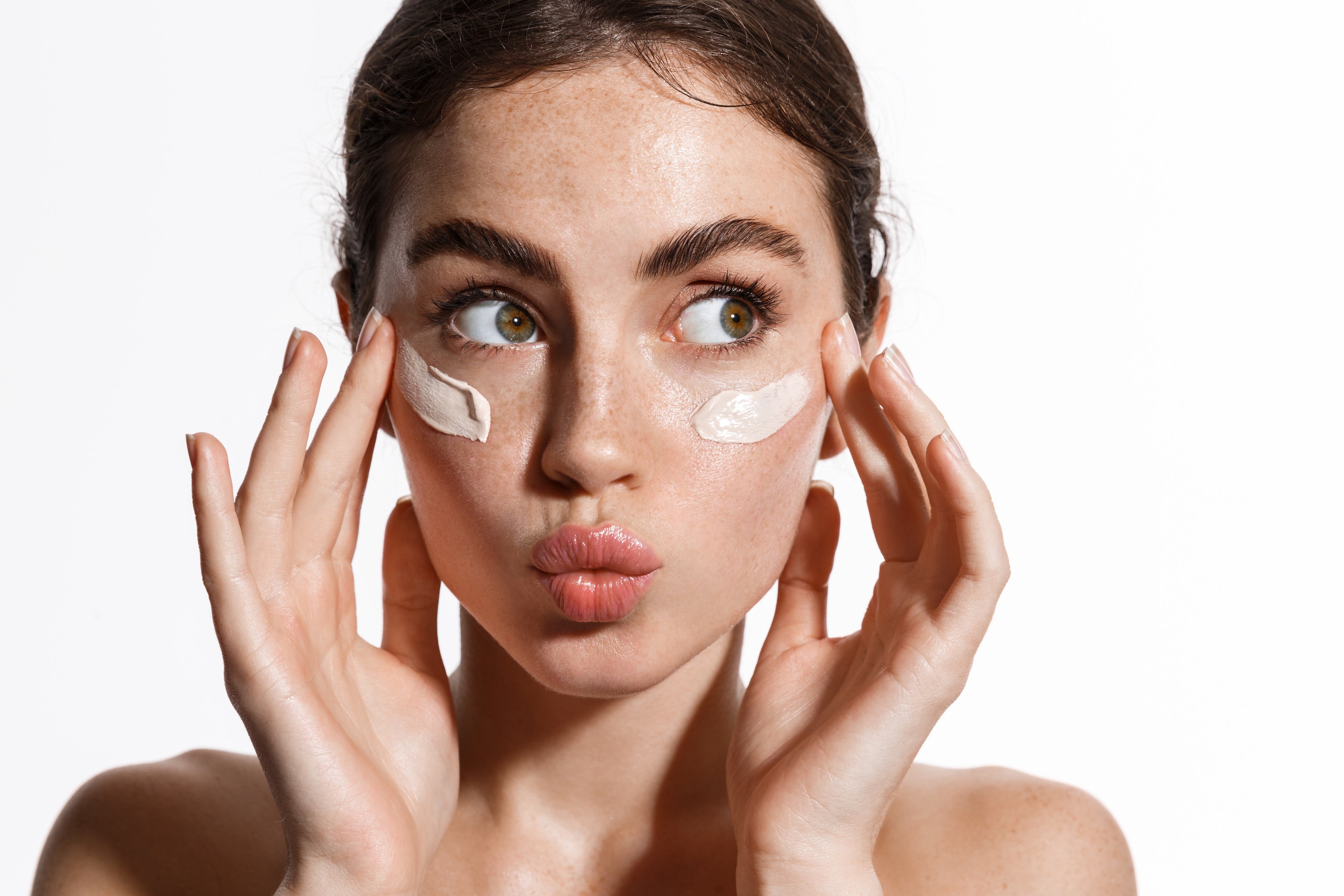 “Close-up of a woman applying herb rich clay skincare on skin”