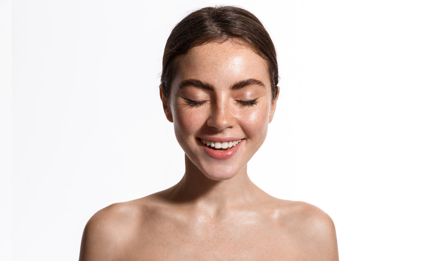 “Woman with eyes closed after applying facial mist against a white background”