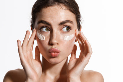 “Close-up of a woman applying herb rich clay skincare on skin”