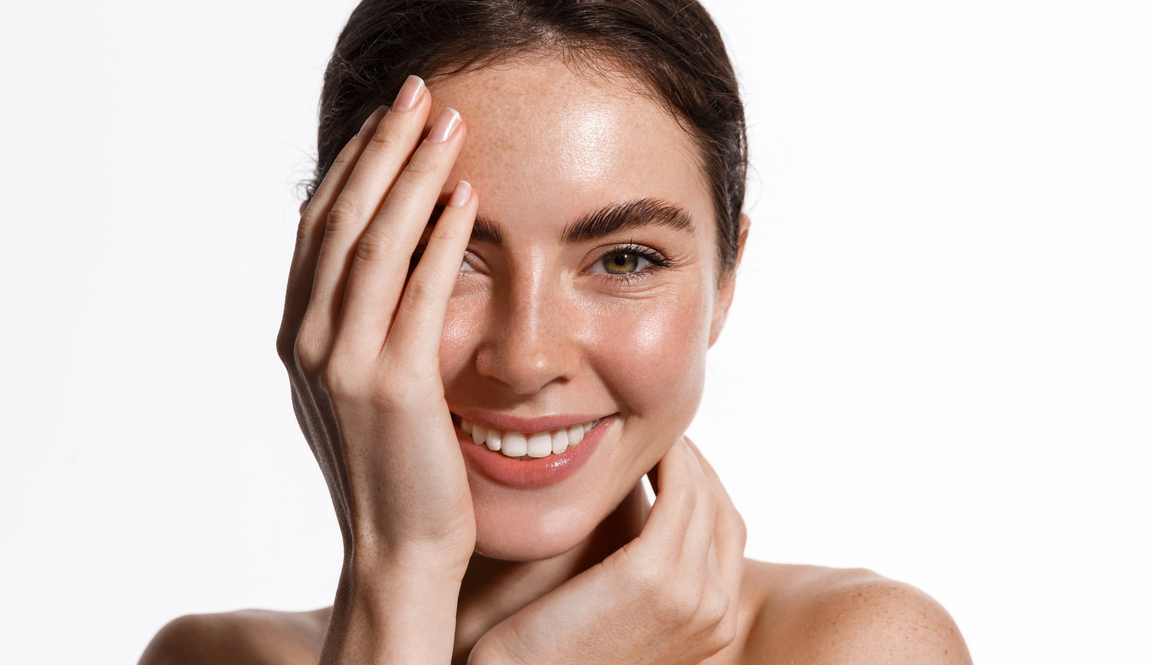 “Woman with fresh, clean skin after cleansing, smiling against white background”
