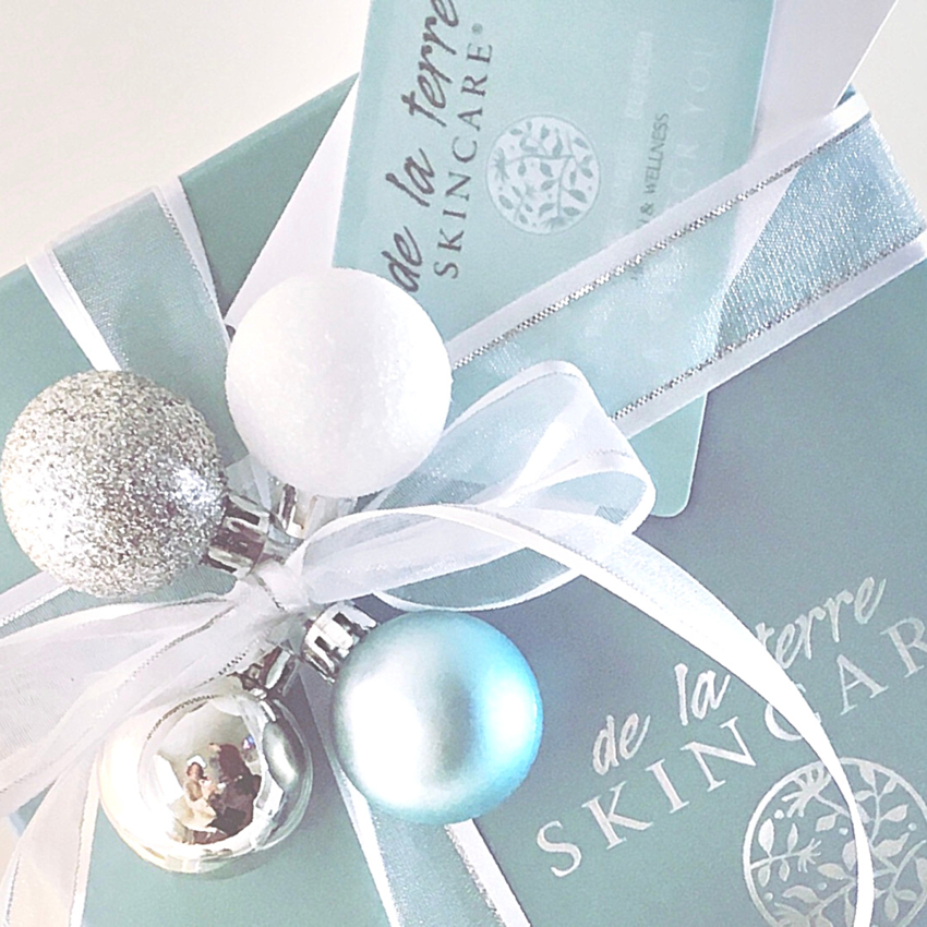 De La Terre Skincare gift card styled with ribbon and seasonal ornaments