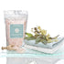 “Mineral Rich Salts by De La Terre Skincare in resealable pouch with folded towels and wooden scoop”